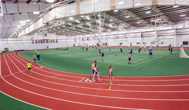 People running on and gathered around an indoor track
